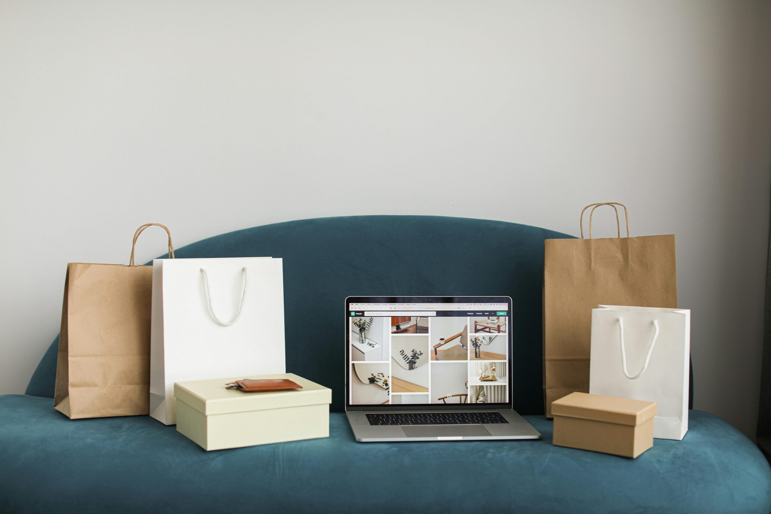 Laptop displaying an online store beside shopping bags and packaging supplies, representing ecommerce working capital needs for growing online businesses.